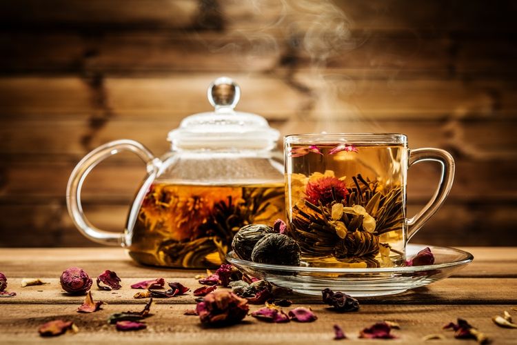 Kvitnúci čaj v sklenenej konvičke na čaj