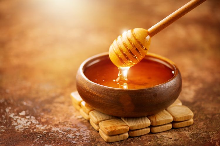 Zlatistý med v hnedej nádobe